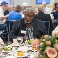 Three event attendees in conversation while sitting at table